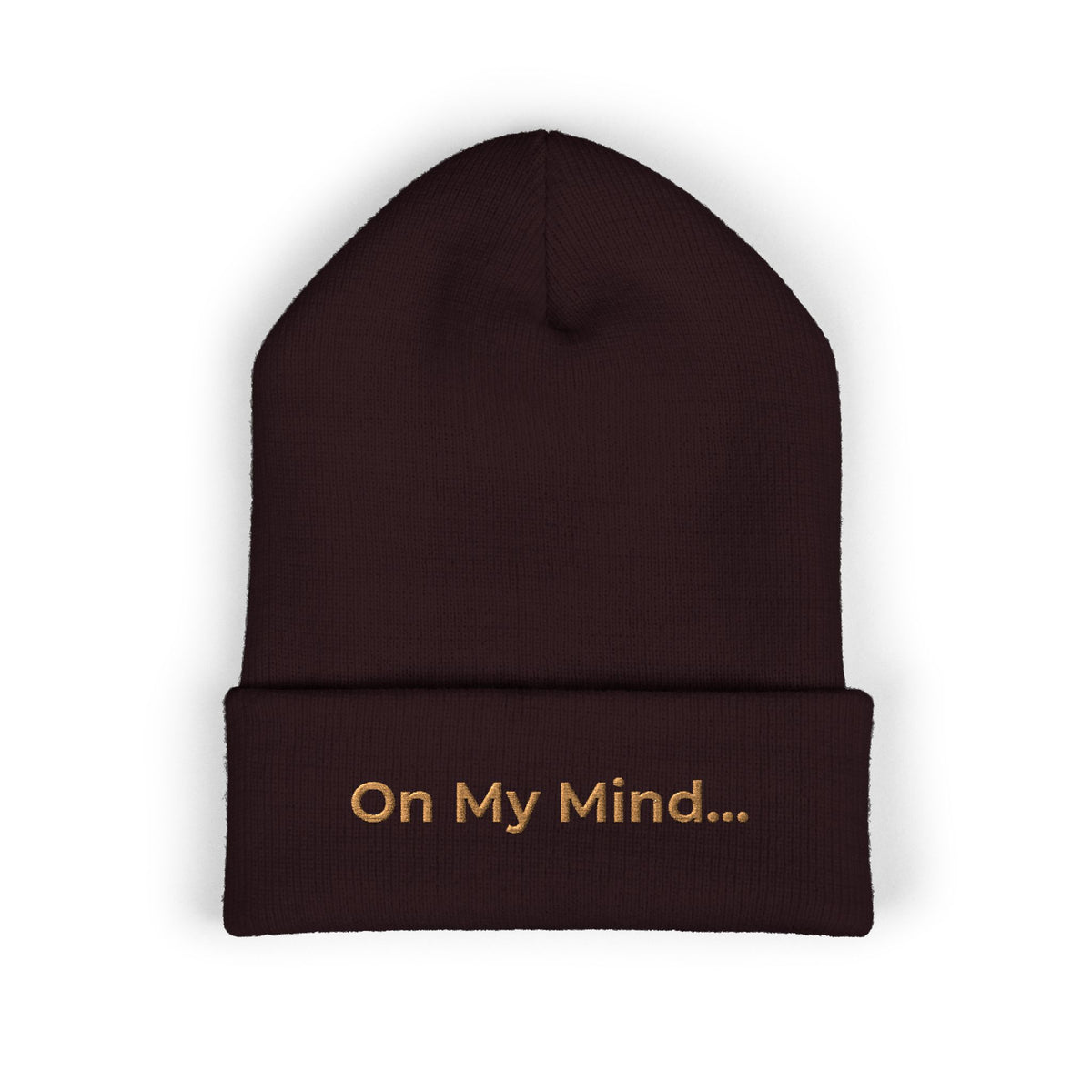 Brown cuffed beanie with gold “On My Mind...” embroidery on the front.