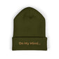 Olive cuffed beanie with gold “On My Mind...” embroidery on the front.